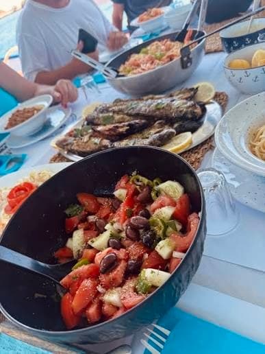 Greek salad and grilled fish spread on the boat